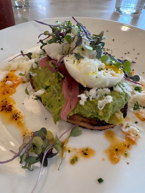 Avocado toast with poached eggs and microgreens